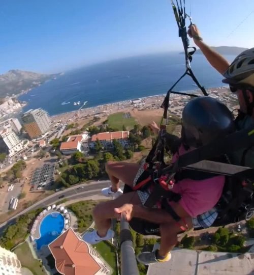 Preparation for landing after the flight with a paragliding instructor above Becici